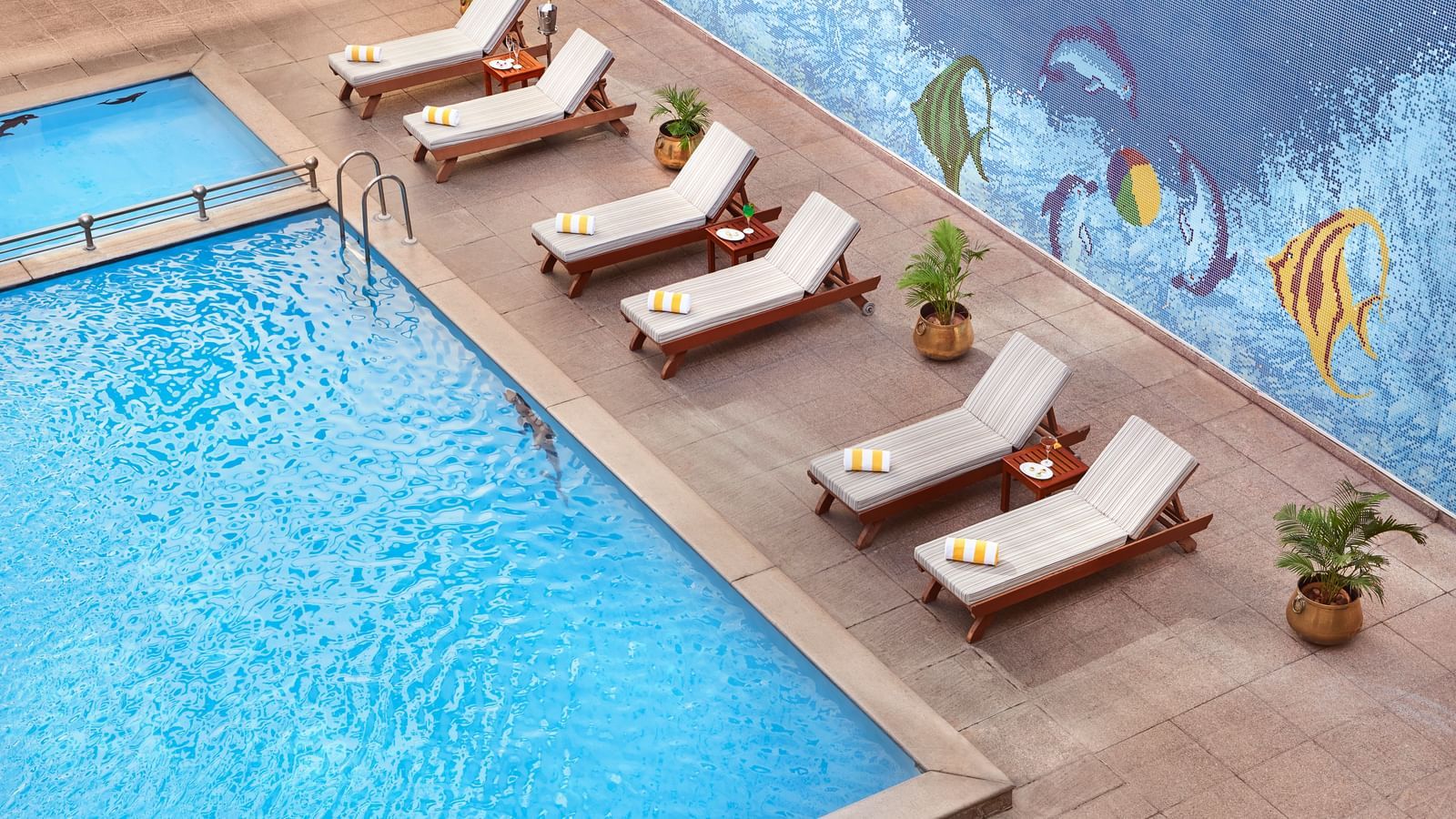 An image of a pool and next to it there are lounger beds at Accord Puducherry